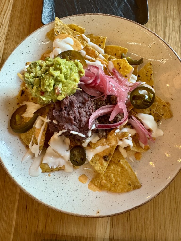 MustNachos im Mustachos in Krakau. Tortillachips mit Bohnen, Guacamole, Köse, Zwiebeln
